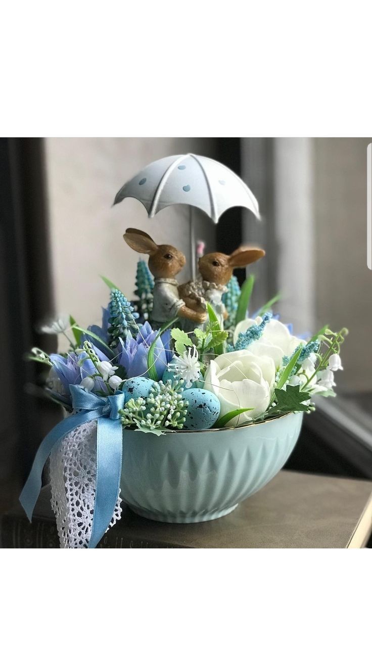 a vase filled with flowers and rabbits holding an umbrella