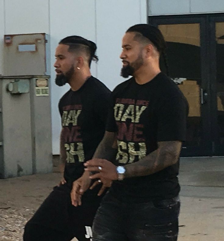 two men in black shirts standing next to each other