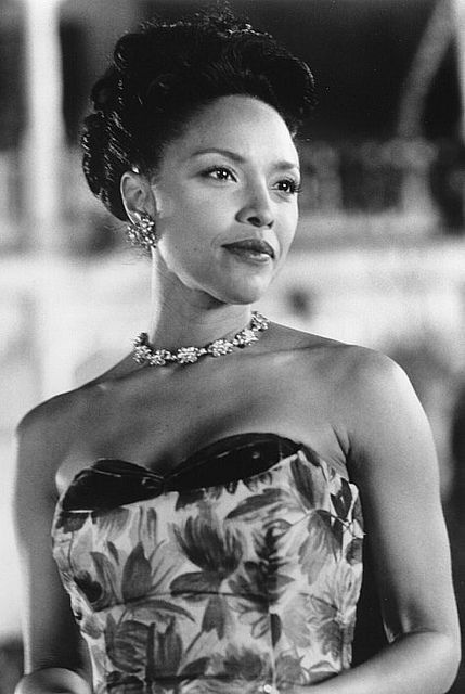 an old photo of a woman in a dress and necklace with flowers on her chest