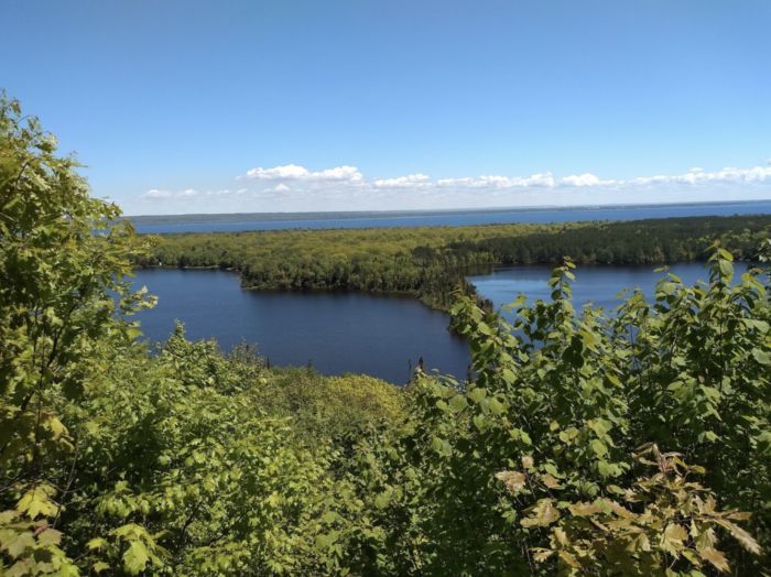 a lake surrounded by trees on a sunny day