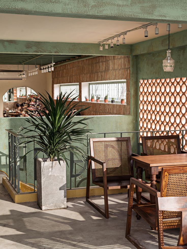 an outdoor dining area with chairs, tables and a potted plant on the balcony