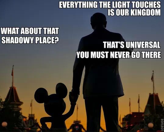 the silhouette of a man holding hands with a mickey mouse in front of a castle