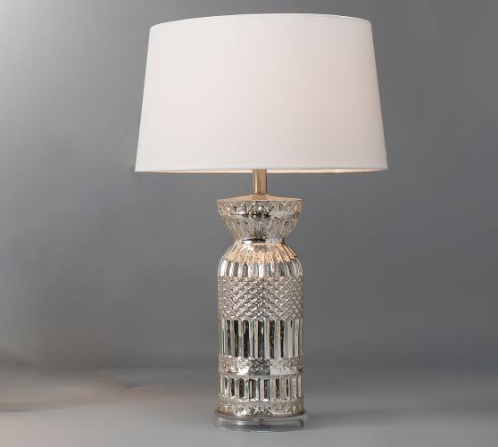 a glass table lamp with a white shade