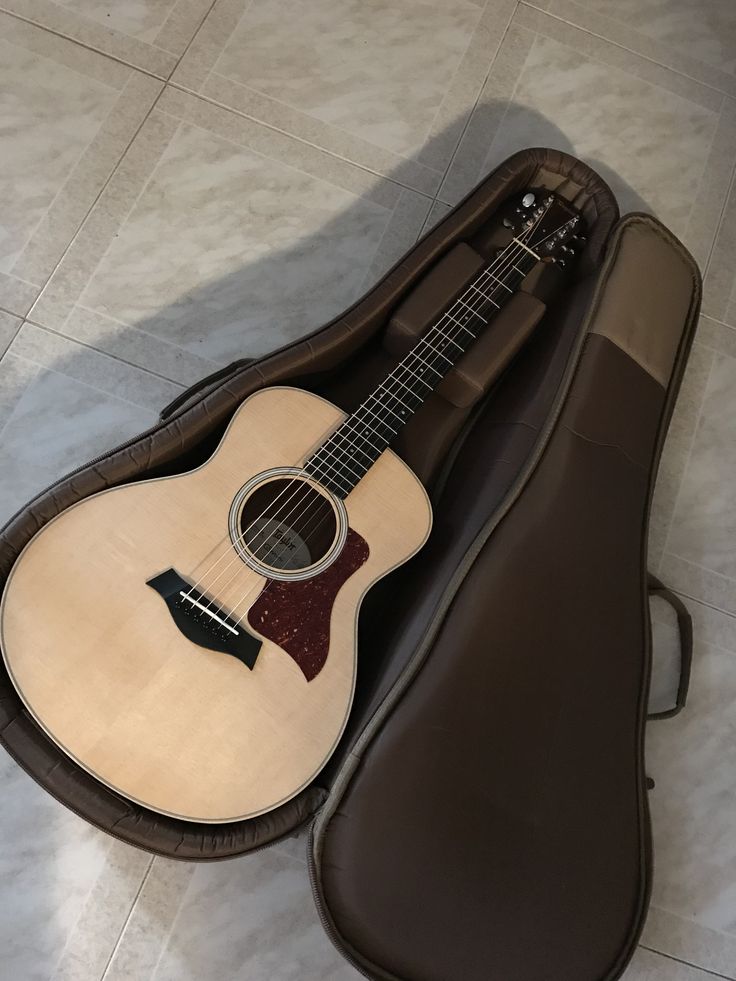an acoustic guitar in its case on the floor
