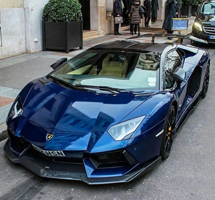 a blue sports car is parked on the street