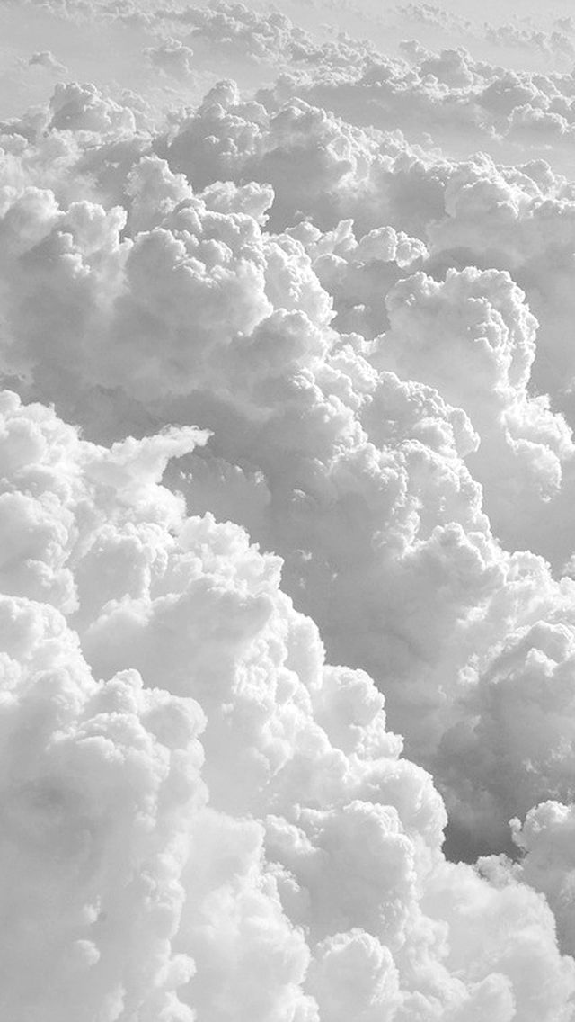 black and white photograph of clouds in the sky from an airplane window, looking down