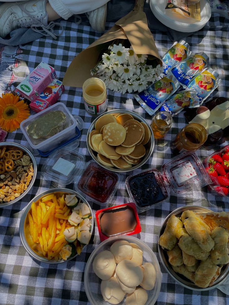 a table topped with lots of food on top of a blue and white checkered table cloth