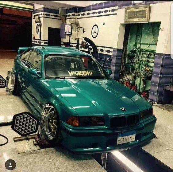 a green car is parked in a garage