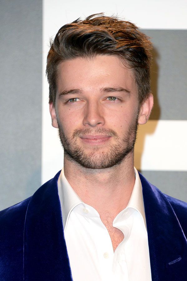 a close up of a person wearing a blue suit and white shirt with a beard