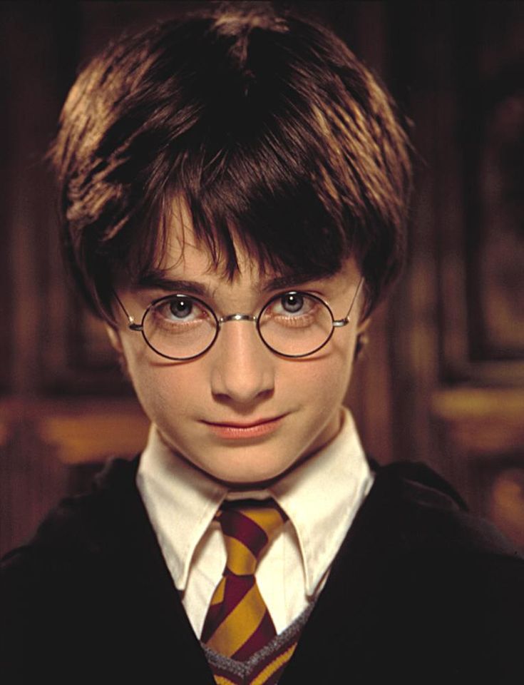 the young harry potter is wearing glasses and a tie