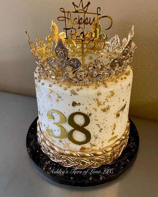 a birthday cake decorated with gold and silver decorations