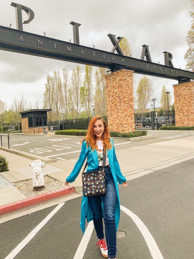 a woman standing in the middle of an empty parking lot