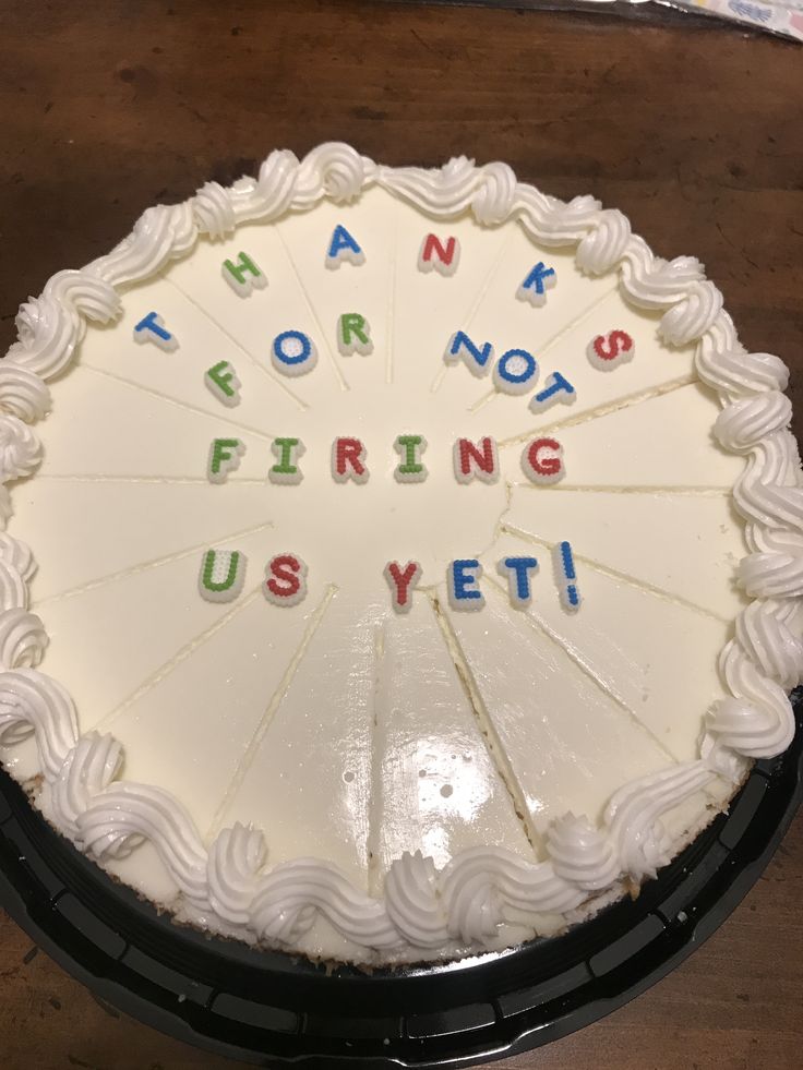 a white cake with writing on it sitting on top of a wooden table next to a knife