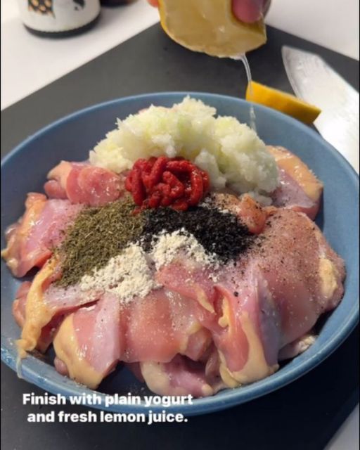 a blue bowl filled with meat and vegetables