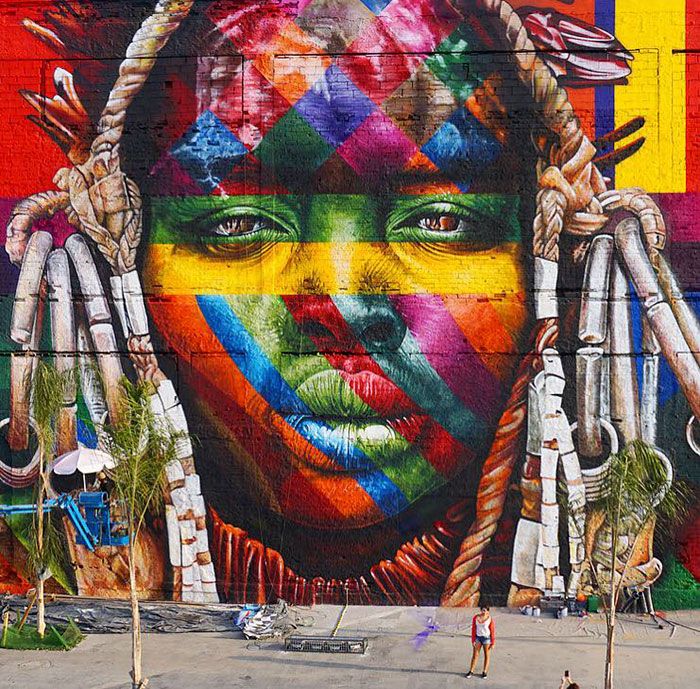 a large colorful mural on the side of a building with a woman's face painted in multicolors