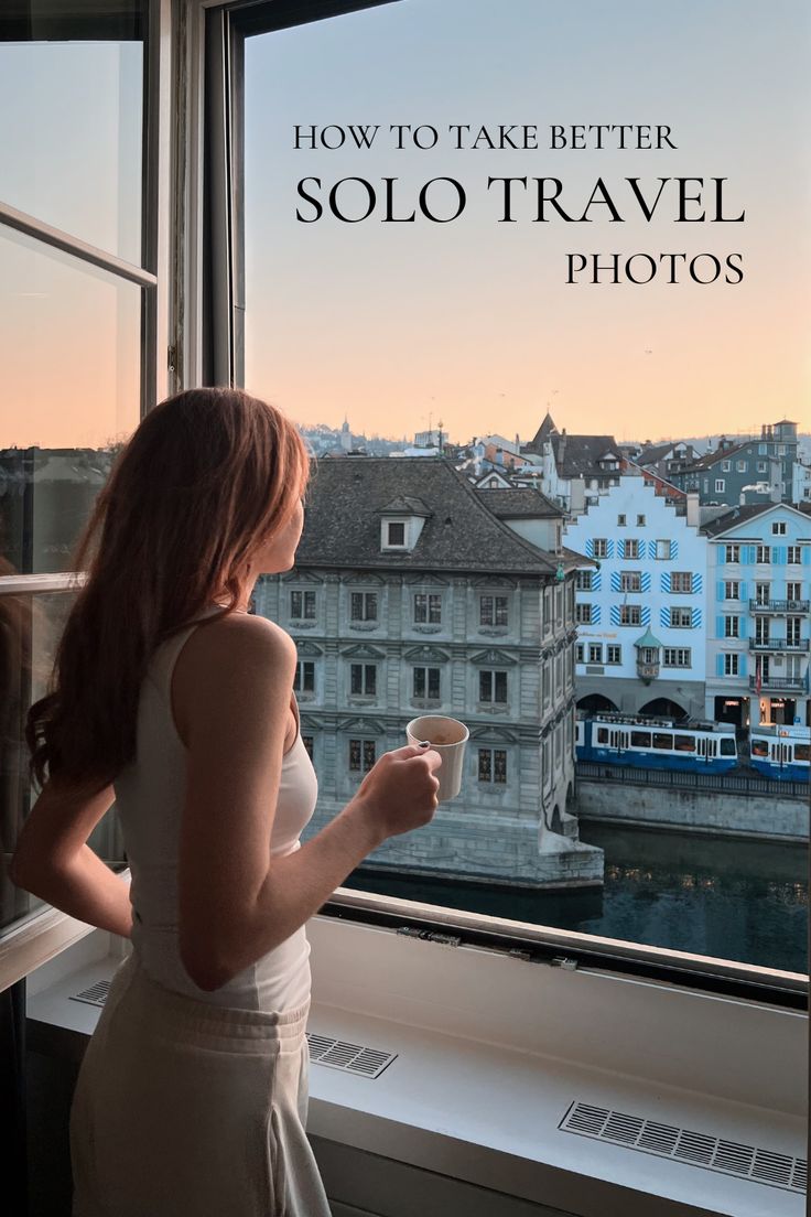 a woman standing in front of a window looking out at the water and buildings with text overlay that reads how to take better solo travel photos