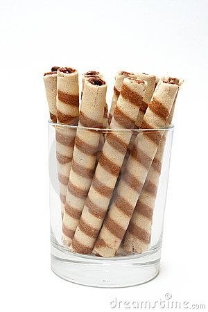 several brown and white striped cookies in a glass