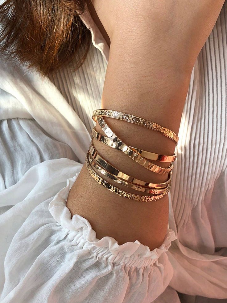 a woman wearing three different bracelets on her arm