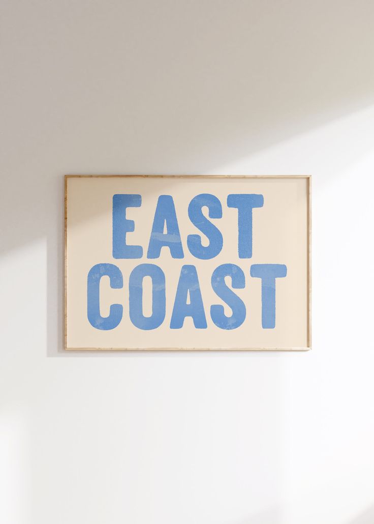 a sign that says east coast hanging on the wall in front of a white wall