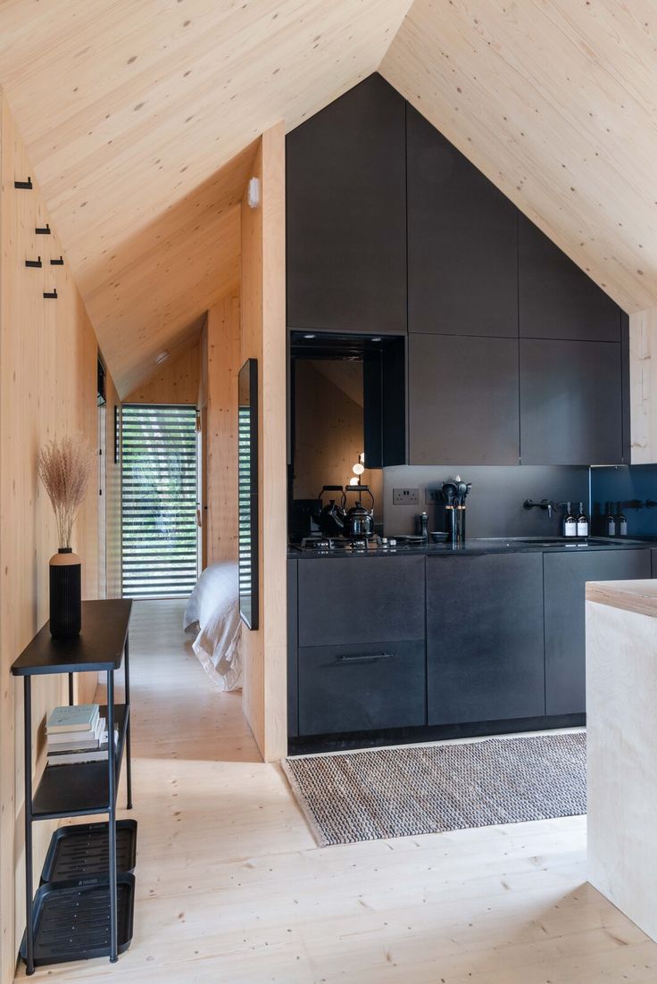 an open kitchen and dining area in a house with wooden walls, flooring and ceiling