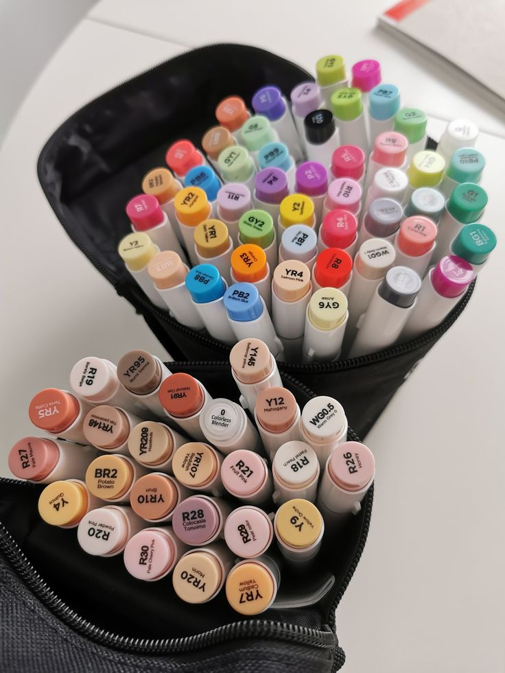 a black case filled with lots of different colored crayons and markers on top of a white table