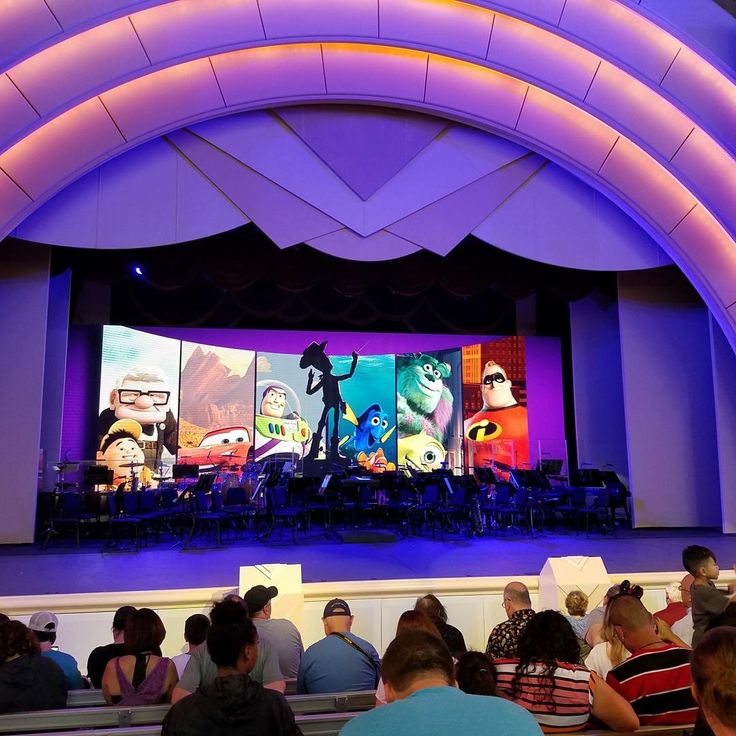 people sitting in front of a large screen with cartoon characters on it