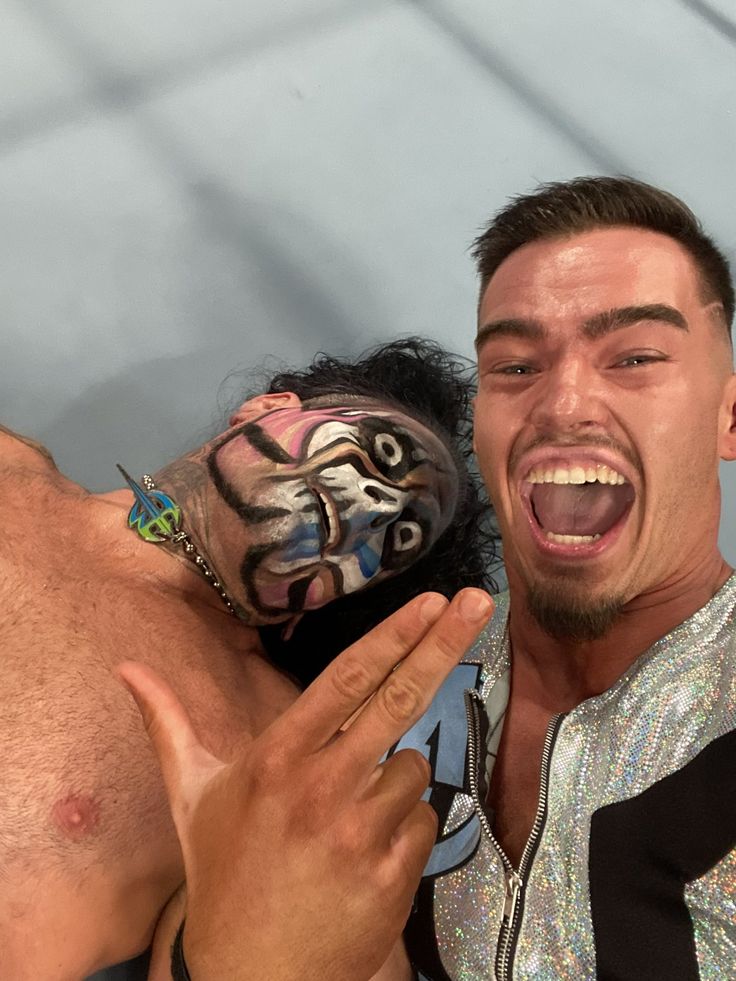 two men with face paint on their faces and one is holding his hand out to the other