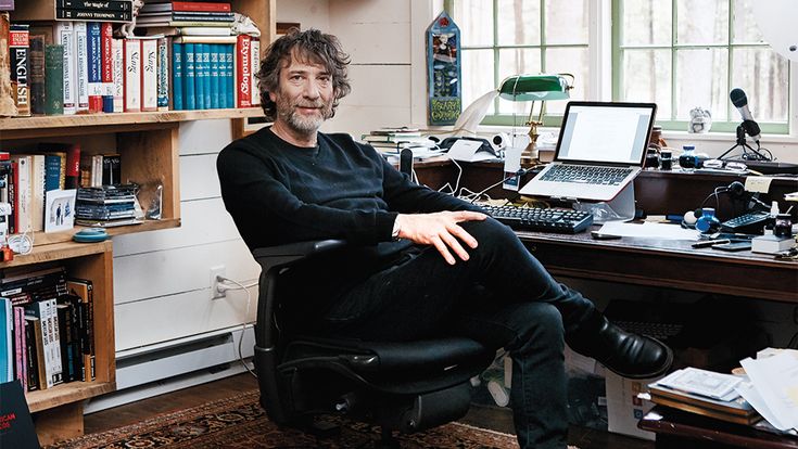 a man sitting in an office chair next to a desk