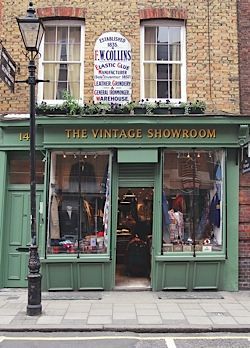 the vintage showroom is located in an old brick building with green shutters and windows