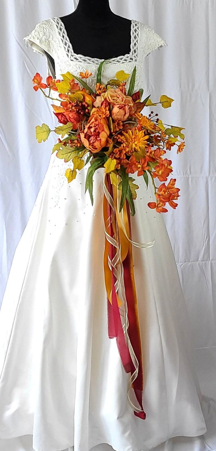 a white dress with orange and yellow flowers on it