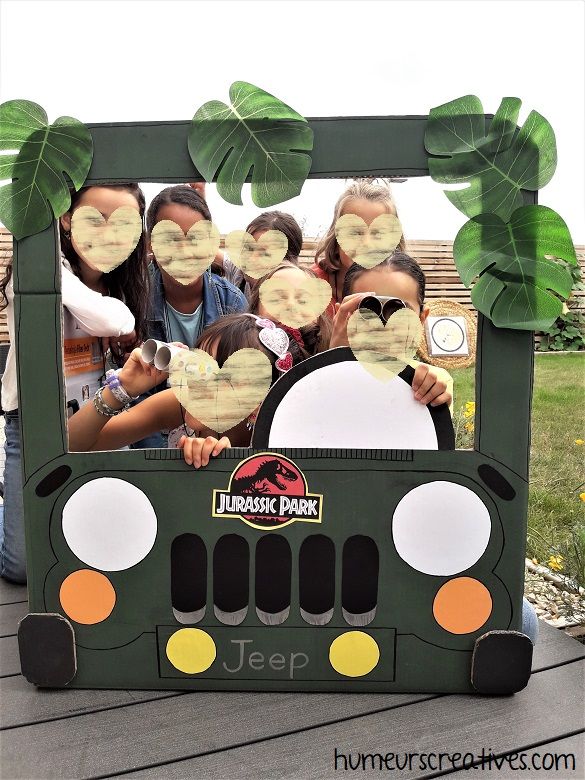 a group of kids are posing in front of a jeep frame with their faces cut out