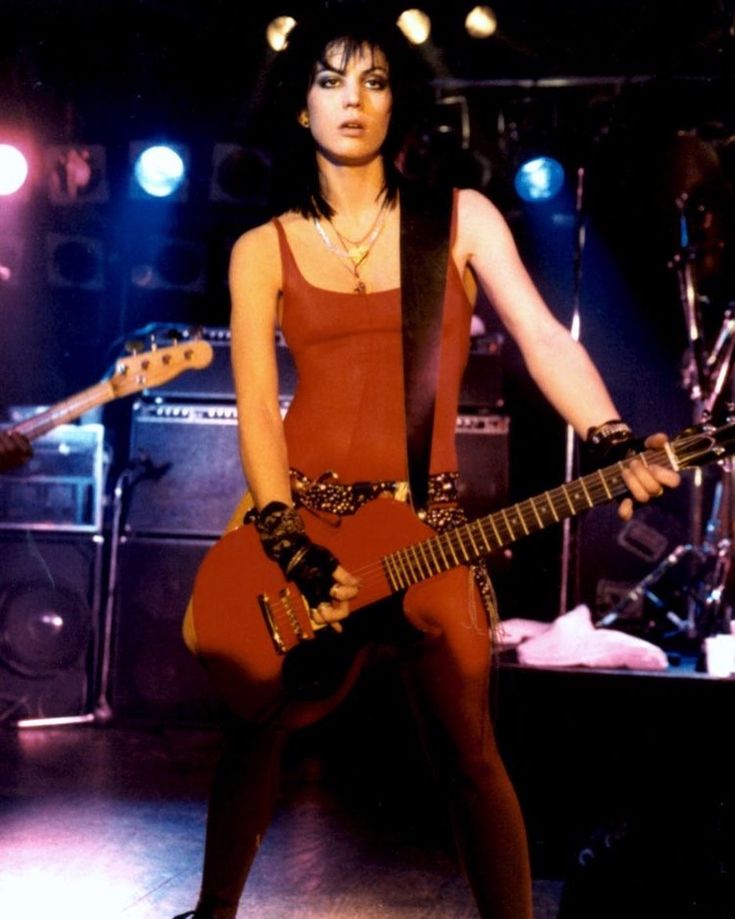 a woman with an electric guitar on stage