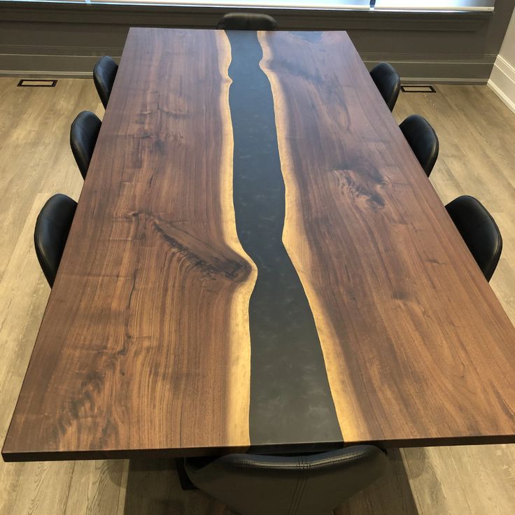 a wooden table with black leather chairs around it