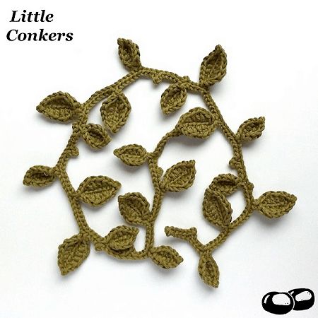 crocheted leaves are arranged in the shape of a tree on a white background