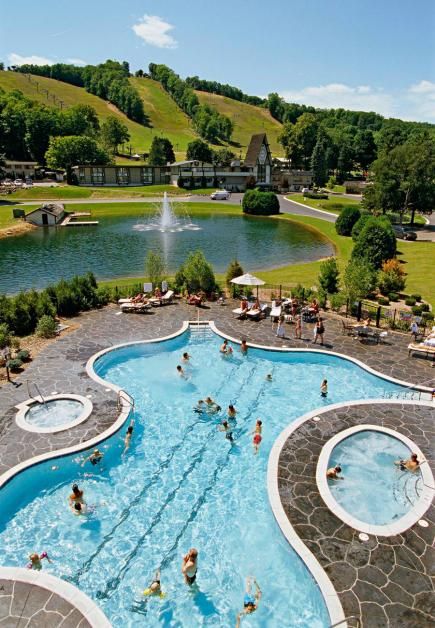 an outdoor swimming pool with people in it