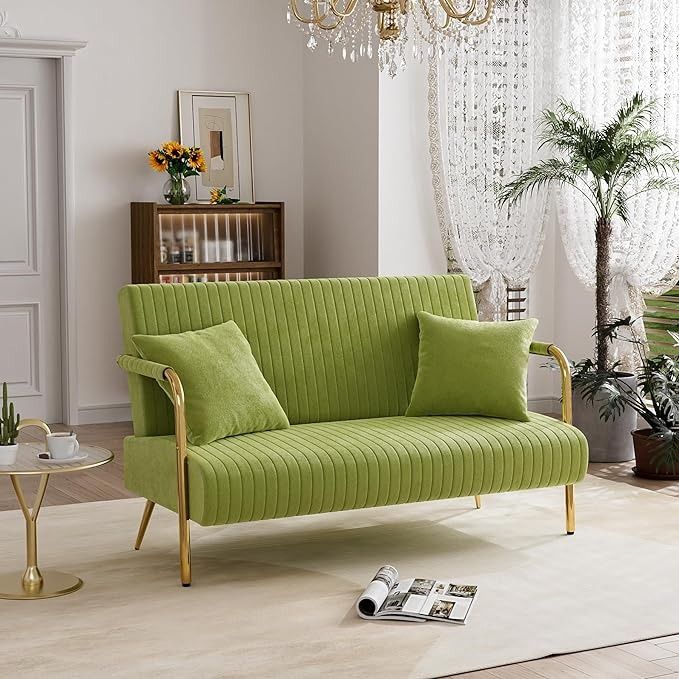 a living room with a green couch and chandelier