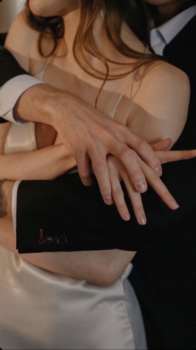 a man and woman hugging each other with their hands on the back of one another