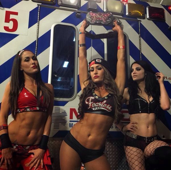 three beautiful women in bikinis standing next to a fire truck