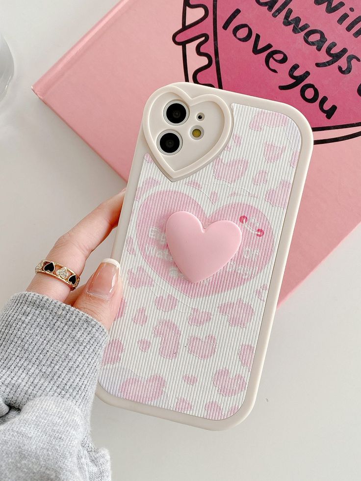 a person holding a phone case with a heart on it