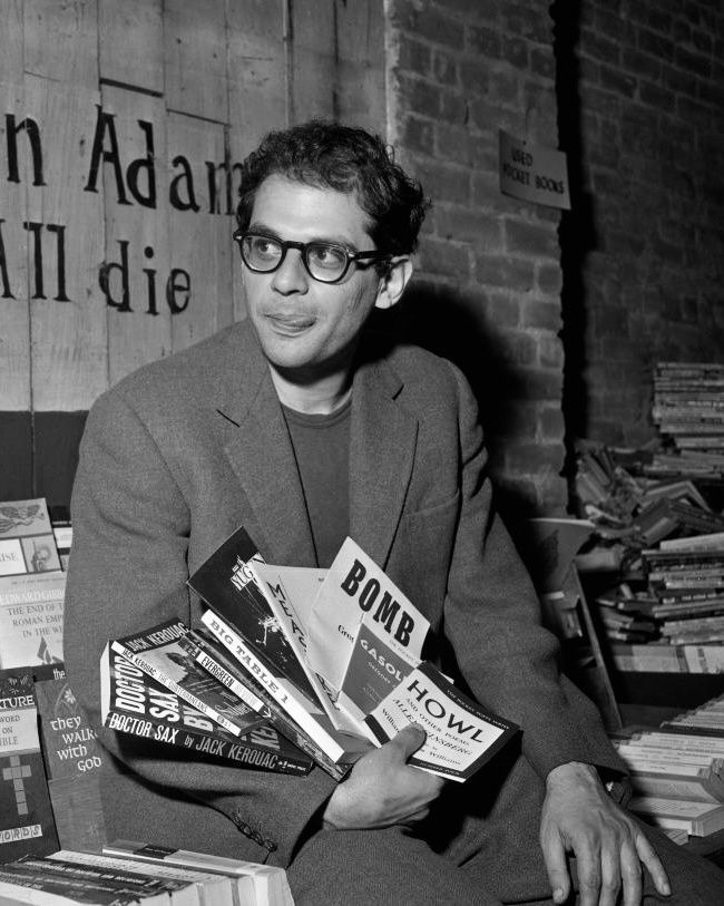 a man sitting in front of a pile of books