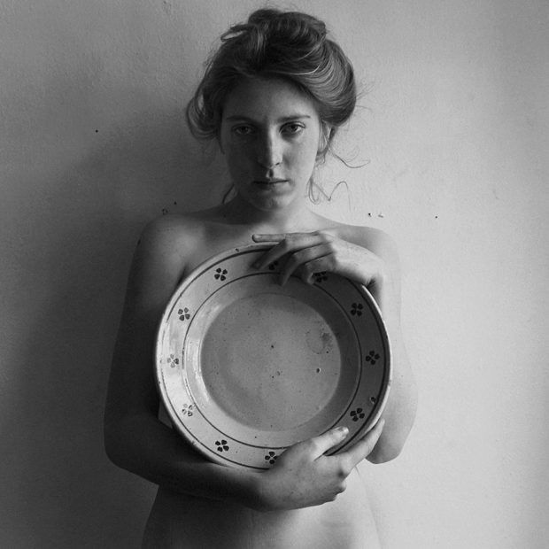 a naked woman holding a plate with paw prints on it's front and side