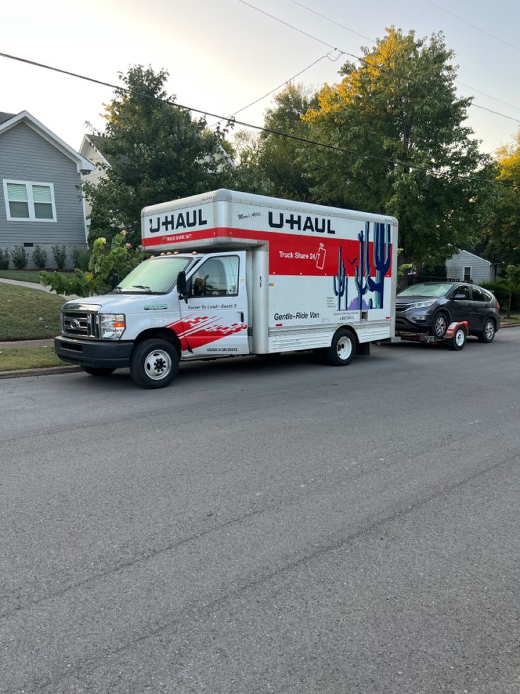 a delivery truck is parked on the side of the road next to a car in front of a house