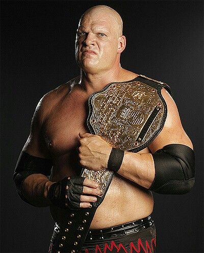 the wrestler is posing with his wrestling belt