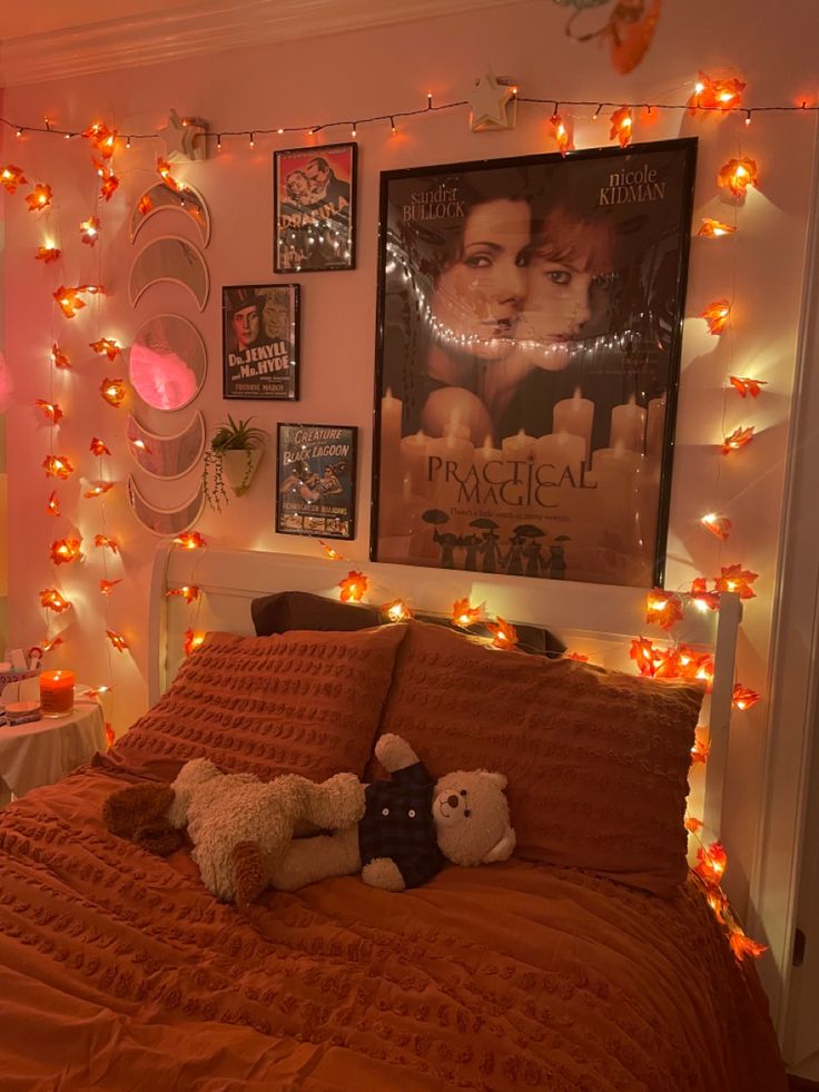 a bedroom decorated in orange and white with lights strung from the ceiling, teddy bears on the bed