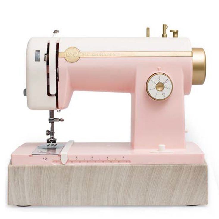 a pink sewing machine sitting on top of a wooden block