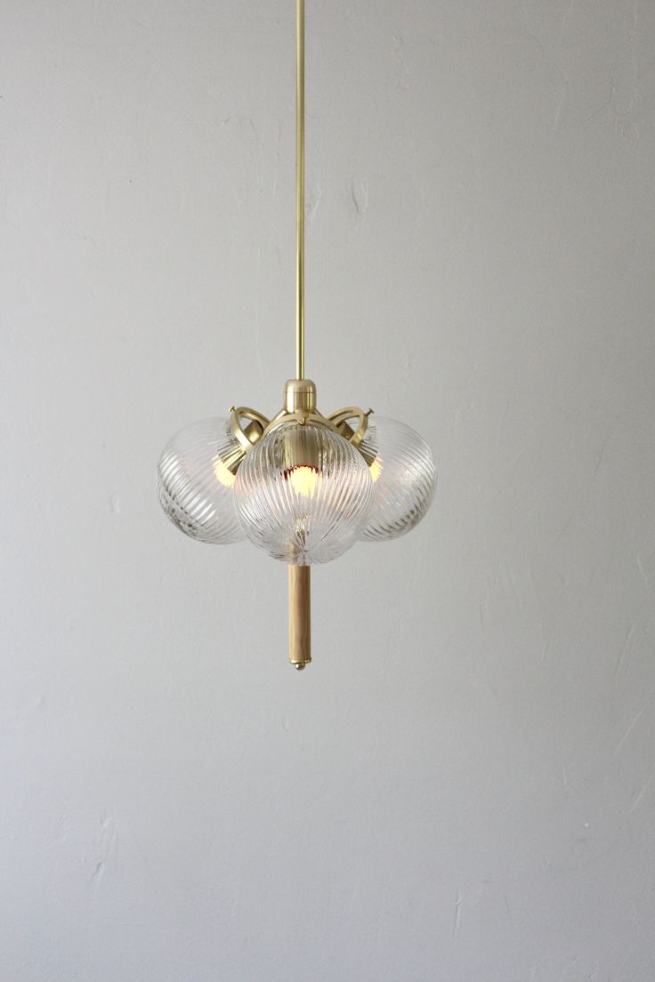 a light fixture hanging from the ceiling in a room with white walls and flooring