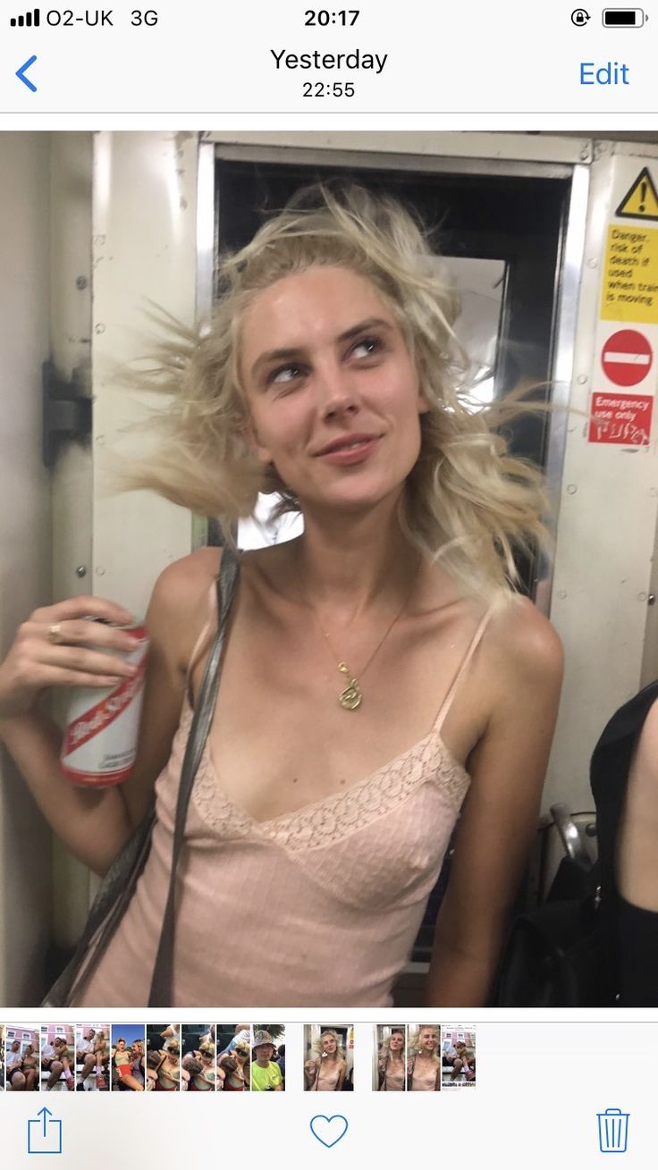 a woman is taking a selfie with her hair blowing in the wind and holding a can of soda