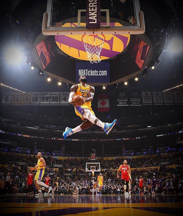 a basketball player jumping up in the air to dunk a ball at a game