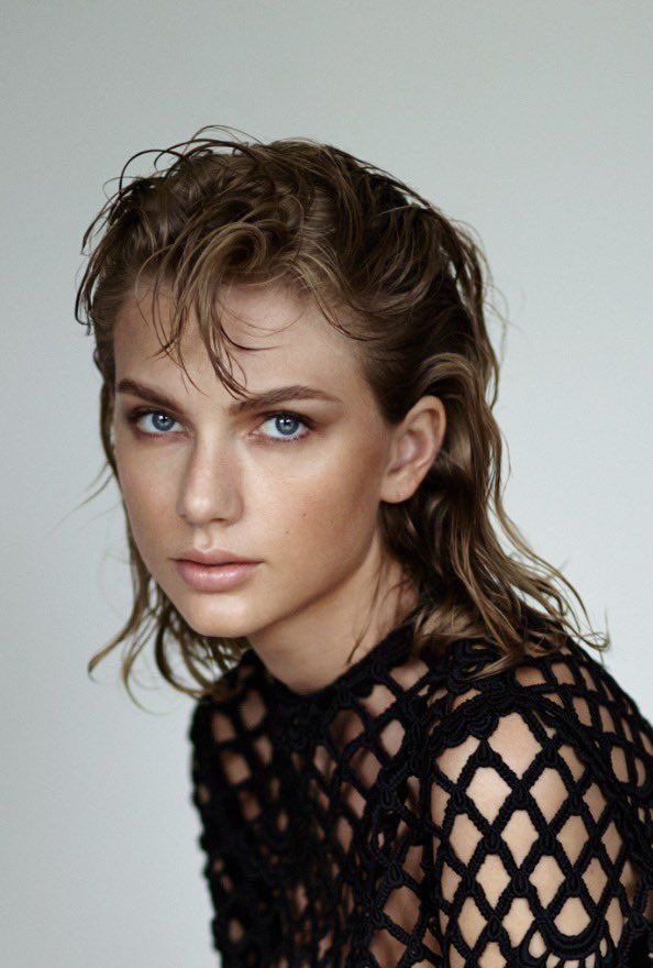 a young woman with blue eyes wearing a black lacy top and posing for the camera