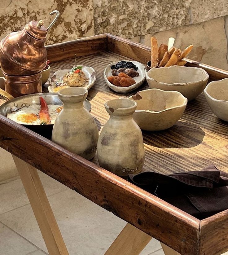 a wooden table topped with bowls and dishes